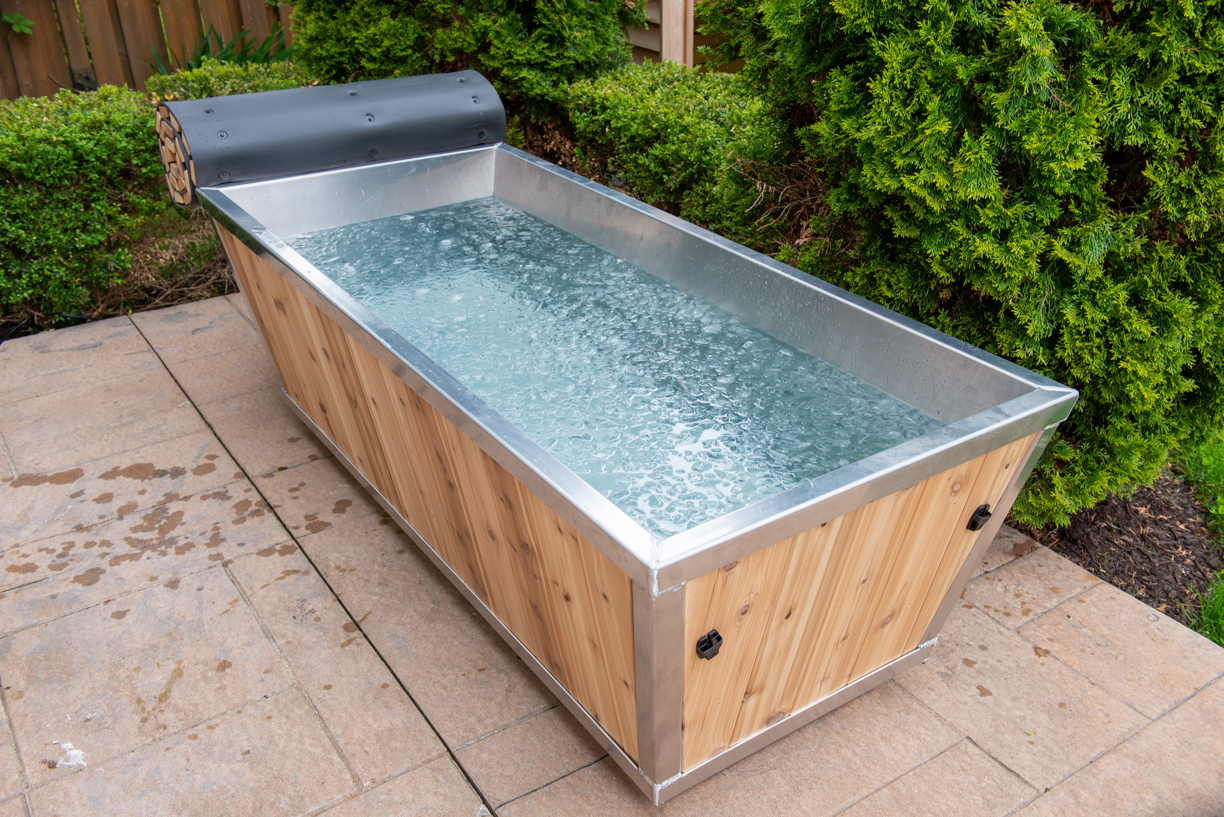 Canadian Timber Polar Cold Plunge filled with water on a landscaped patio